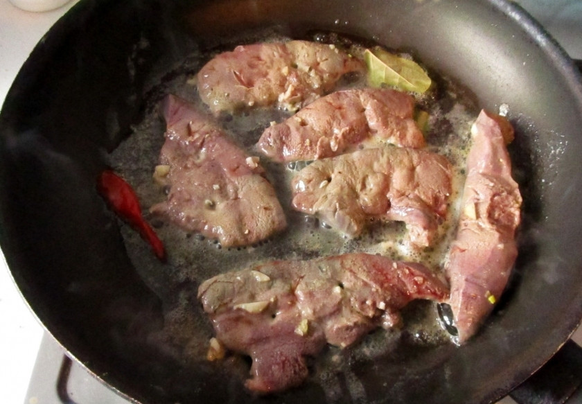 1. Этап. Жареная телячья печень: Обжаривать телячью печень надо на сливочном масле, можете кинуть те же ингредиенты, например, чили перчик и лавровый лист. Не нужно очищать печень от маринада. Если на ней остался чеснок, пусть будет. Обжарьте каждый кусочек телячьей печени с обеих сторон по минуте, даже чуть меньше.