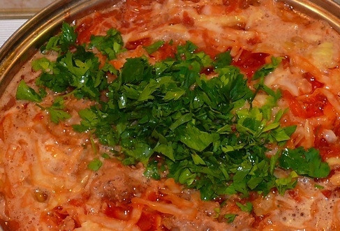 1. Этап. Вкусный борщ с тушенкой: 11. Добавьте измельченную свежую зелень, перемешайте и через пару минут снимите с огня. Накройте кастрюлю крышкой, пусть борщик настаивается еще минут 20 до подачи.