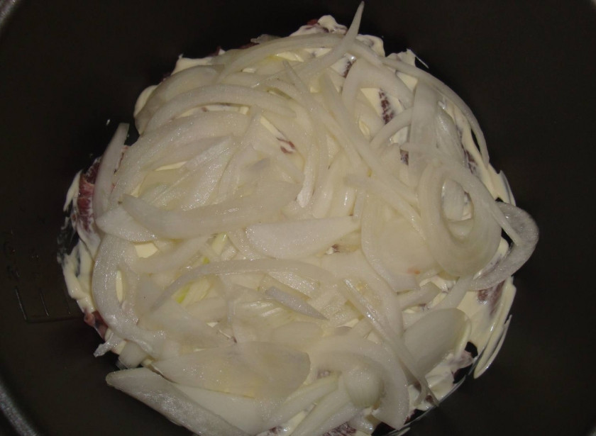 1. Этап. Говядина в мультиварке Панасоник: Порежьте лук полукольцами, переложите к говядине.