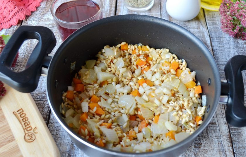 1. Этап. Перловая каша с фасолью, тыквой и беконом: Добавьте к овощам перловую крупу, чеснок, перемешайте. Влейте вино и дайте испариться жидкости. Крышкой не накрывать! После влейте куриный бульон и варите перловку до готовности.