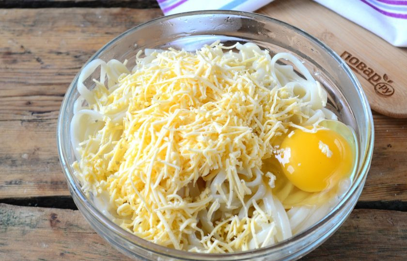 1. Этап. Пирог из спагетти под сыром: Готовые спагетти смешайте с яйцами, добавьте соль, если вы не добавляли ее в процессе варки. Хорошенько перемешайте полученную смесь.
