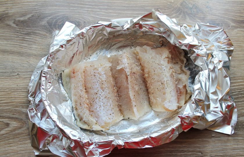 1. Этап. Запеченная хоки: В форму для запекания налейте немного воды и застелите форму фольгой. То есть должна получиться водяная прослойка, чтобы рыба не прилипла к фольге. Рыбу посолите и поперчите, выложите на фольгу кожей вниз.