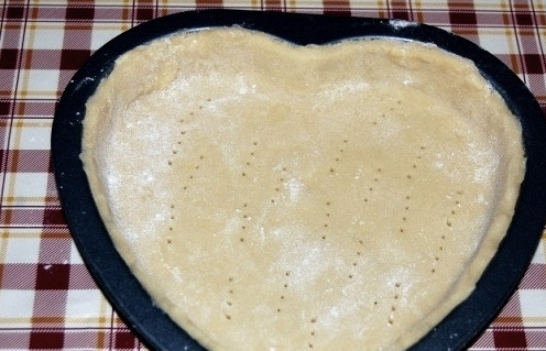 1. Этап. Сладкий пирог на День Святого Валентина: 10. Форму для выпечки смажьте маслом, посыпьте мукой, излишки муки стряхните. Положите в форму нижний пласт, оформите бортики, основание наколите вилкой.