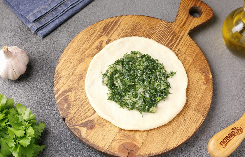 1. Этап. Ароматные чесночные лепёшки: Каждый кусочек теста раскатайте в форме круга и отступив от краёв, выложите начинку.