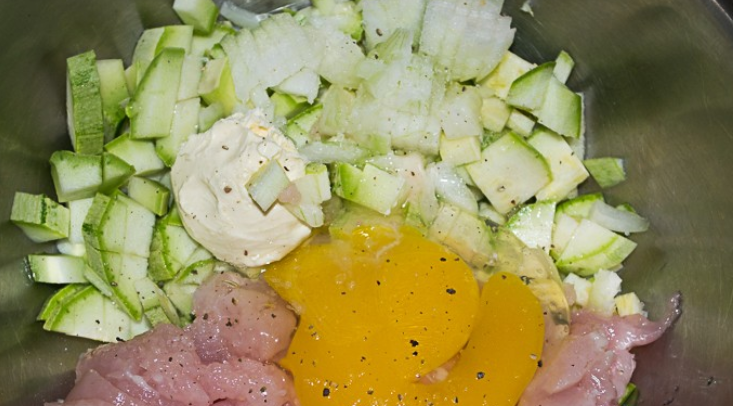 1. Этап. Курица с кабачками в сметане: Кабачки промываем и нарезаем кубиками, филе также нарезаем кубиками. Лук измельчаем. Смешиваем ингредиенты в глубокой емкости, добавив яйца, сметану, соль и перец.