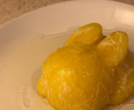 1. Этап. Желе Солнечный зайчик с ананасовым смузи: 9. В случае с охлажденной тарелкой: наливаем немного желе в то место, где будет устанавливаться кролик. Мы как-бы заклеиваем основание зайчика, чтобы не было преждевременного оттаивания. 10. Выкладываем замороженного смузи-зайчика и аккуратно поливаем его желатином. Медленно, но без пауз как в предыдущем варианте. Красиво просуществовать такой вариант может при комнатной температуре (около 25С) в течении 40-50 мин, а потом смузи в кролике растает и ферменты ананаса начнут расщеплять желе. Более длительным сроком годности обладает вариант со стаканом, где он остается стабильным намного дольше (несколько часов), но не оставляйте его на ночь в холодильнике, так как желе полностью растворится. Вариант с тарелкой подходит в качестве украшения торта, но готовить надо перед подачей. Пока гости съедят основное блюдо, за это время ледяной зайчик превратится в более мягкий вариант. Это понравится все любителям фруктового льда и мороженного.