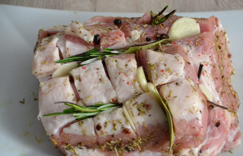 1. Этап. Свиной карбонат в рукаве в духовке: Смажьте ароматной смесью мясо, нарежьте пластинками дольки чеснока, сделайте в мясе проколы, вставьте в них чеснок, лавровый лист, веточки розмарина. Накройте пищевой пленкой, поставьте в холодильник мариноваться примерно на 1 час, можно на более длительное время.