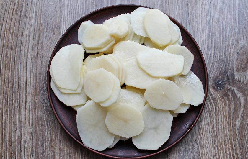 1. Этап. Картофель по-княжески: Картофель очистите, вымойте и порежьте тонкими кружочками.