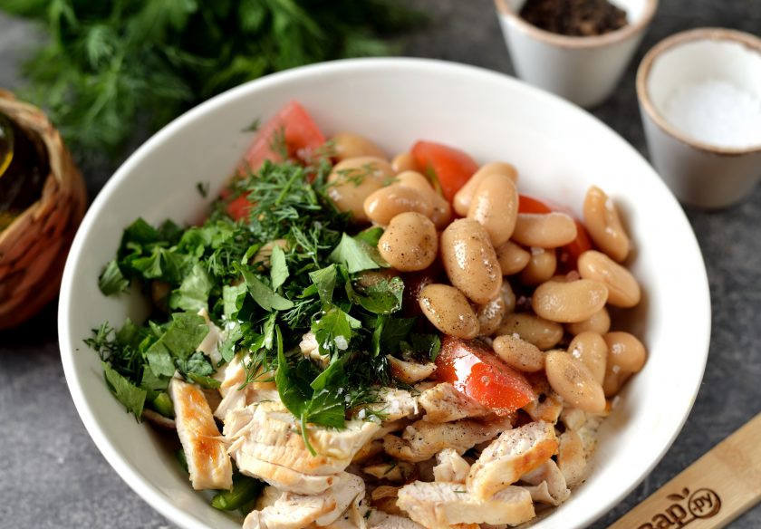 1. Этап. Овощной салат с курицей и фасолью: Порубите свежую зелень, поперчите и посолите салат по вкусу, влейте оливковое масло первого отжима, аккуратно перемешайте салат.