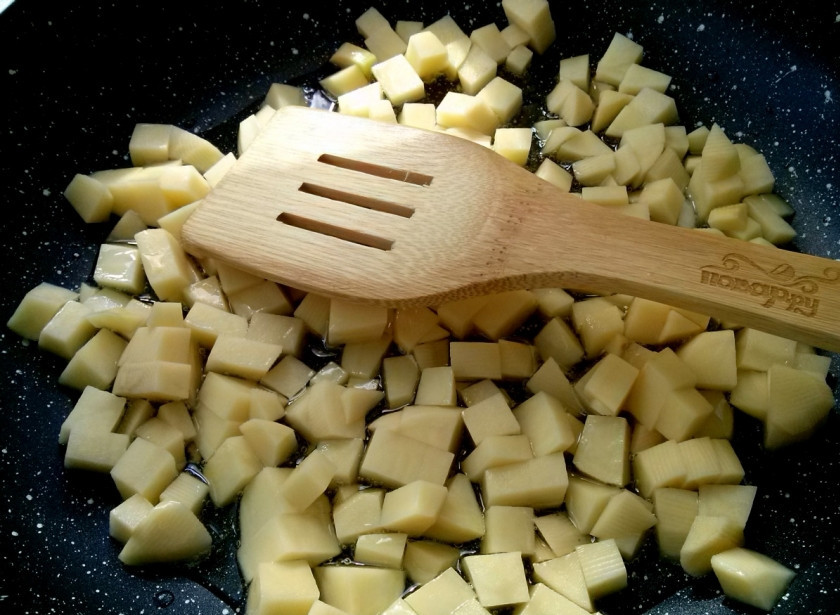 1. Этап. Аджапсандали: 3. Почистите картошку, нарежьте ее кубиками и отправьте в масло на сковородку с острым перцем. Обжаривайте картофель около 5 минут.