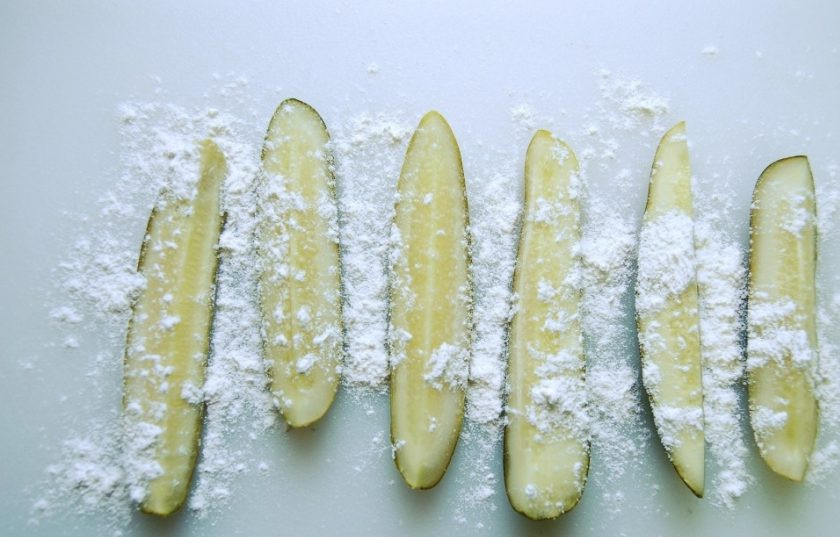 1. Этап. Солёные огурцы в кляре: 4. Огурцы разрежьте на 4 длинных части. Немного присыпьте мукой, а потом опустите в кляр.