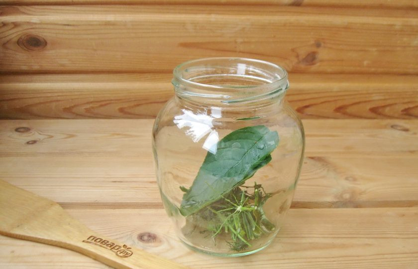 1. Этап. Помидоры кусочками на зиму: В стерилизованную банку выложите зелень: укроп и лист вишни.