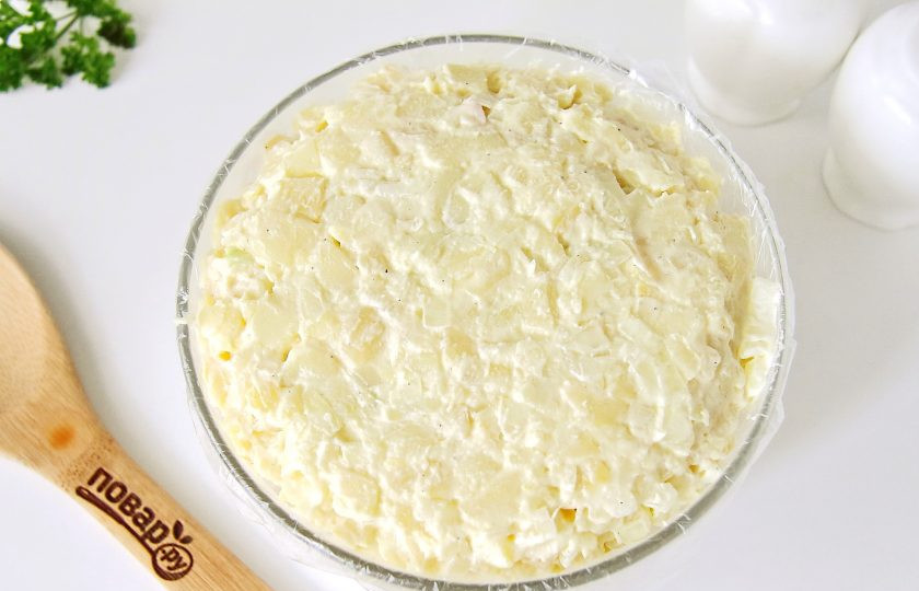 1. Этап. Салат Шарлотка: Сверху выложите ровным, плоским слоем оставшийся картофель. Концами пленки, свисающими по краям, закройте салат сверху. Хорошо примните его руками и уберите для пропитки в холодильник на пару часов.