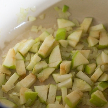 1. Этап. Тушеная красная капуста: В толстостенной кастрюле растопите сливочное масло. Добавьте чеснок, обжарьте 30 секунд до появления запаха, затем добавьте мелко нарезанный лук. Обжарьте лук до мягкости, около 5 минут, после чего добавьте яблоки и жарьте еще 1 минуту.