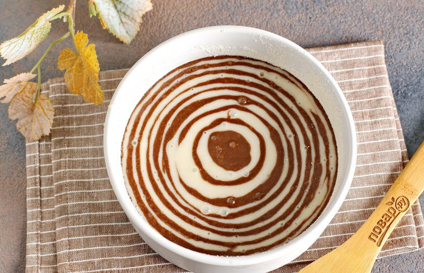 1. Этап. Торт Зебра в микроволновке: Смажьте маслом подходящую для микроволновки форму. Дно и бока можно обсыпать мукой или манкой. Посуда должна быть настолько большой, чтобы тесто заполнило ее лишь наполовину. Теперь по очереди выкладывайте столовой ложкой белое и шоколадное тесто, чтобы образовывались четкие круги. Я начинала с шоколадного теста. Берем примерно по 1-2 ст.л. каждого вида теста.