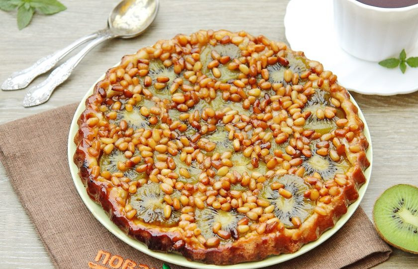 1. Этап. Пирог-перевертыш с киви и кедровыми орешками: Выпекайте при 200 градусах 20 минут. Дайте выпечке немного остыть, после чего переверните на плоское блюдо начинкой вверх. Пирог-перевертыш с киви и кедровыми орешками готов.