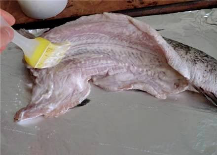 1. Этап. Щука со сметаной в духовке: На противень выкладываем лист фольги, а на него кладем рыбу, натираем ее солью и смазываем сметанным соусом со всех сторон.