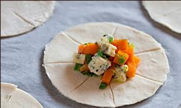 1. Этап. Пирожки с тыквой: В центр каждого кружочка выкладываем начинку, состоящую из кубиками нарезанных всех ингредиентов данного рецепта (кроме оливкового масла и слоеного теста, естественно).