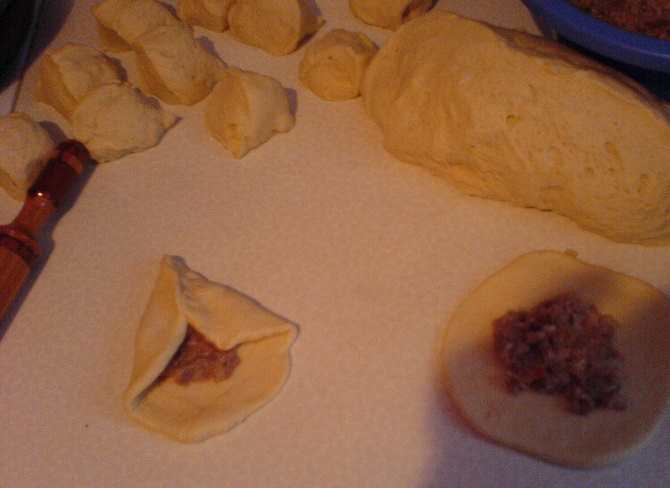 1. Этап. Треугольники с ветчиной: Замешиваем тесто. Засыпаем в миску муку, разбиваем туда яйца, заливаем воды, добавляем дрожжей, сливок, йогурта, соль, сахар. Замешиваем, добавляем разрыхлителя и растительного масла. Месим до однородности. Делим на кусочки и раскатываем в круги.