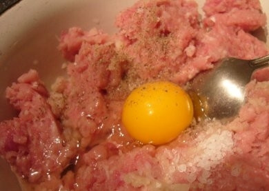 1. Этап. Куриные тефтели на пару: 4) Вбиваем в миску с фаршем яйцо, солим и перчим. В очередной раз перемешиваем, чтобы получилась однородная масса.