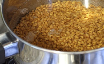 1. Этап. Кутья с изюмом: Залейте в кастрюлю воду, всыпьте пшеницу и поставьте вариться на большом огне, без крышки. Варить до мягкости, примерно 20-30 минут. Затем снимаем с огня кастрюлю, ставим остывать. Большую часть пшеничного отвара перелейте в другую емкость, немножко отвара оставьте в кастрюле с пшеницей.