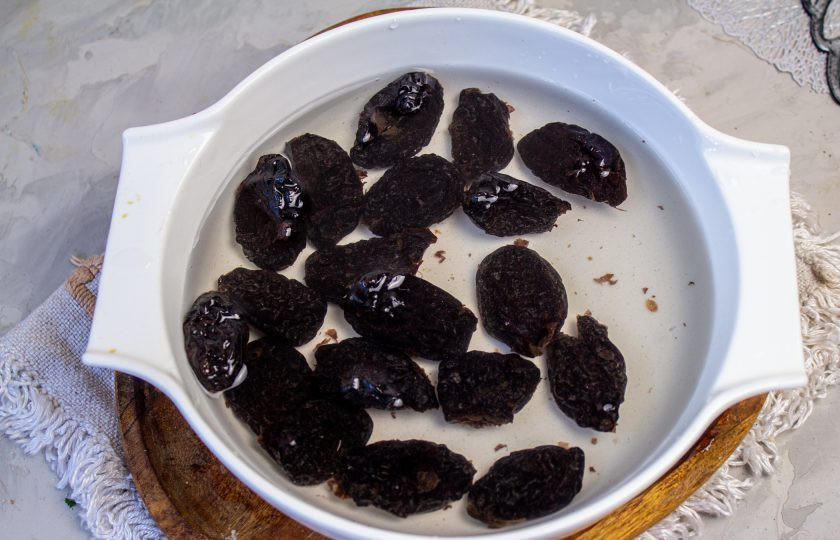 1. Этап. Салат с копченой курицей, черносливом и грецкими орехами: Чернослив замочите в горячей воде на 5-10 минут, а затем промойте, обсушите и нарежьте на небольшие кусочки.