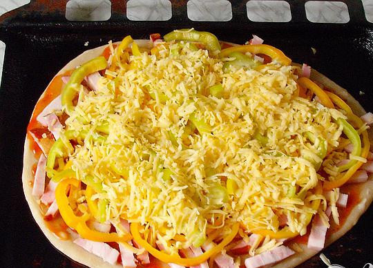 1. Этап. Пицца с колбасой: 4. Смесью томатного соуса и майонеза смазываем подпеченный корж. Майонез и томатный соус мы смешивали ровными частями, хотя можно смешивать на свой вкус. Колбасу выкладываем на смазанный корж, перец ложем сверху колбасы. Пиццу обильно присыпаем натертым на терке сыром.