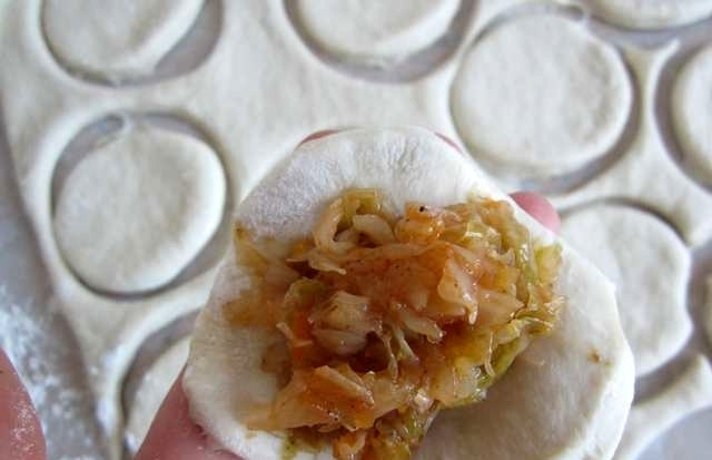 1. Этап. Вареники с капустой на пару: При помощи стакана вырезаем из него кружочки и выкладываем в середину каждого кружочка немного начинки, плотно соединяем края теста.