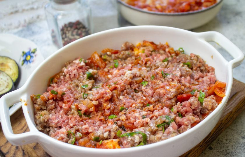 1. Этап. Запеканка из баклажанов по-гречески: Затем ровным слоем выложите половину мясного фарша.