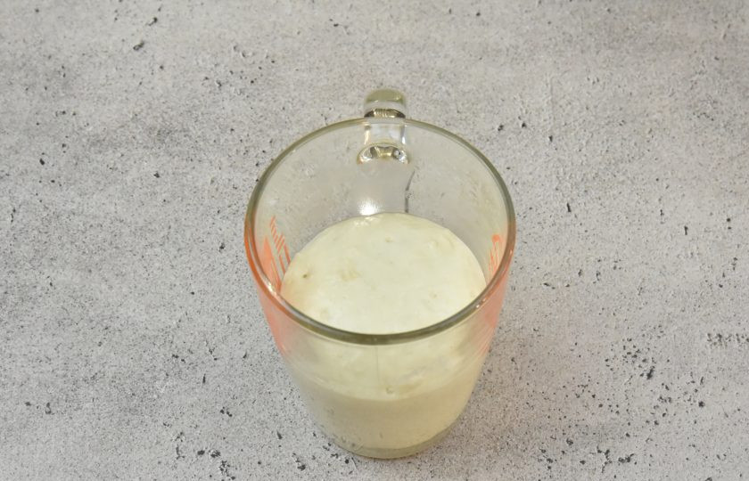 1. Этап. Ремесленный хлеб: Заранее приготовьте опару на закваске. Соедините в емкости 20 грамм закваски, 40 мл. воды и 40 грамм пшеничной муки. Перемешайте, накройте емкость крышкой или пленкой и оставьте при комнатной температуре на 6-8 часов. Это удобно сделать с вечера и утром стартер для приготовления теста будет готов. На пике активности опара увеличится в размере в 2,5-3 раза.