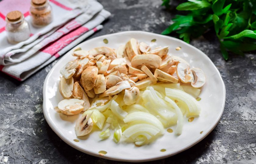 1. Этап. Салат Кальмаровый пир: Очистите лук, грибы вымойте. Нарежьте лук полукольцами, грибы нарежьте пластинами.