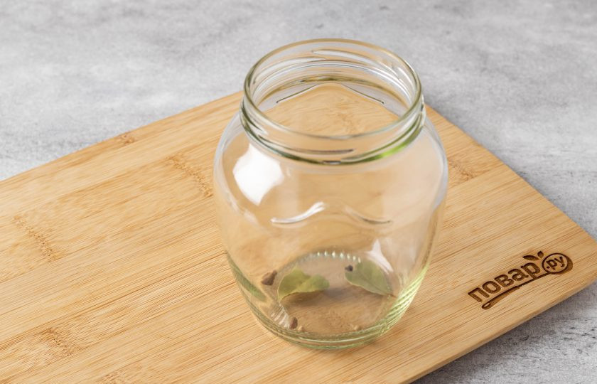 1. Этап. Огурцы маринованные со свеклой на зиму: В чистую стерилизованную банку добавьте очищенный и нарезанный чеснок, лавровый лист, перец горошком.