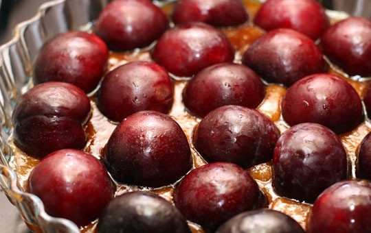 1. Этап. Тарт татен со сливами: Получившуюся карамель выливаем на дно формы, в которой будем выпекать тарт. В карамель выкладываем разрезанные пополам и очищенные от косточек сливы.