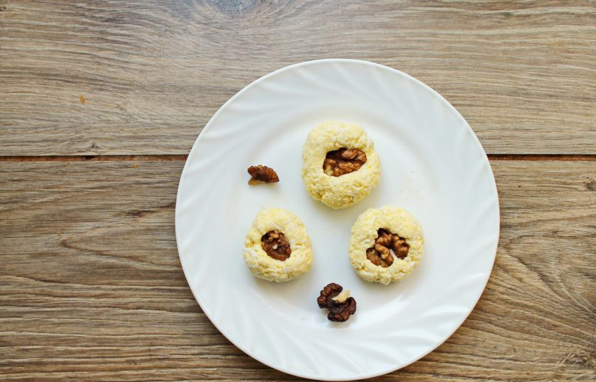 1. Этап. Закусочные конфеты: Разделите массу на одинаковые части и сформируйте шарики. Вдавите в середину каждого сырного шарика половинку или четвертинку ядра грецкого ореха. Снова сформируйте шарики с орехами внутри.