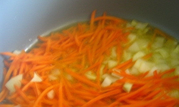 1. Этап. Тушеная капуста: В кастрюле с толстым дном разогрейте масло. Обжарьте в нём пару минут нашинкованный лук и морковь, нарезанную тонкой соломкой.