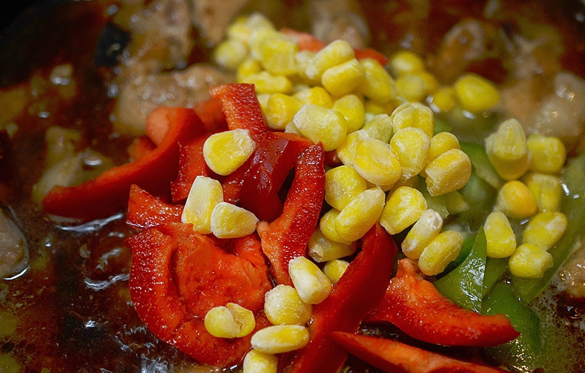 1. Этап. Тушеная говядина по-мексикански: 5. Добавьте к мясу перец и кукурузу. Тушите еще 15 минут. При необходимости добавьте воды.