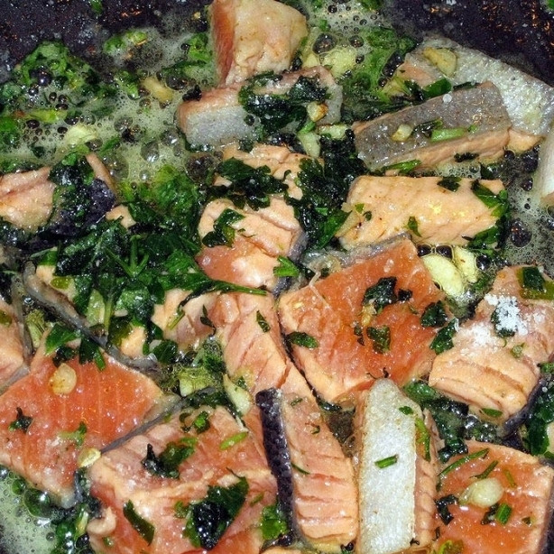 1. Этап. Ризотто с красной рыбой: Добавляем в сковороду небольшие кусочки красной рыбы, обжариваем вместе с чесноком и зеленью примерно 5 минут.