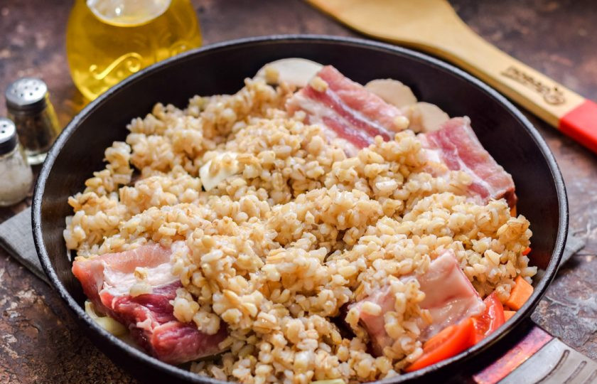 1. Этап. Ребрышки с перловкой: Перловку отварите отдельно, на стакан крупы, два стакана воды. Добавьте перловку в сковороду, влейте стакан воды, добавьте специи, тушите под крышкой 60 минут на небольшом огне.