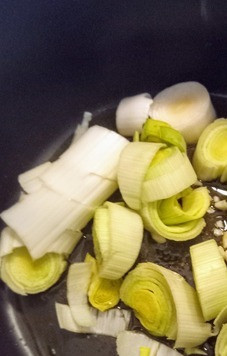 1. Этап. Рагу из нута и креветок: В глубоком казане разогреть оливковое масло, лук-порей, перец красный жгучий и чеснок. Готовить на сильном огне 4 минуты..