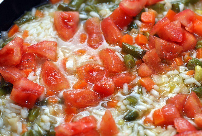 1. Этап. Ризотто с фасолью: Вливаем (порционно) пол литра горячего овощного бульона. Доводим ризотто до кипения и варим на медленном огне, под крышкой. Рис должен впитать всю жидкость. К почти готовому рису, добавляем помидоры. Варим еще 10 минут.