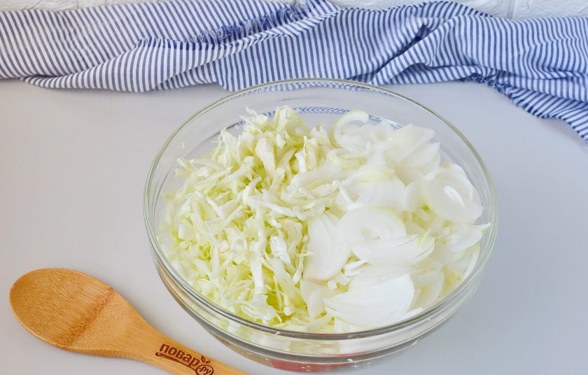 1. Этап. Салат с капустой на зиму: Тем временем нашинкуйте капусту, порежьте тонкими полукольцами лук. Выложите овощи в большую удобную миску или кастрюлю.