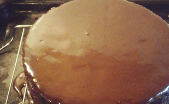 1. Этап. Нежный шоколадный торт: В сотейнике смешайте воду, темный шоколад и сахар. Подогрейте это все на водяной бане и размешайте до полной однородности. Накройте корж второй половинкой и полейте торт глазурью. Поставьте в холодильник, чтобы глазурь полностью застыла. Затем украсьте по вкусу.