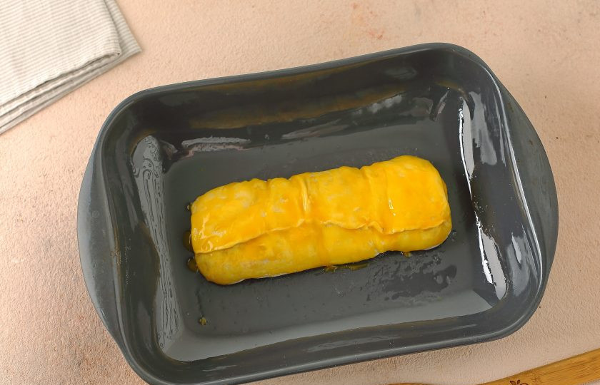 1. Этап. Штрудель с персиками: Переложите рулет аккуратно на противень и смажьте желтком. Запекайте в духовке при температуре 200 градусов около 20 минут. Готовой выпечке дайте остыть, а затем нарежьте и подавайте к столу.