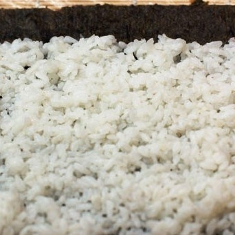 1. Этап. Футомаки с омлетом и шиитаке: На лист нори тонким слоем выкладываем рис, разравниваем. Около 2 см на дальнем краю оставляем нетронутым (смотрите на фото для наглядности).