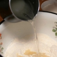 1. Этап. Постные пирожки с капустой: В миске смешиваем муку и сухие дрожжи. В отдельной емкости смешиваем теплую воду, половину масла, соль и сахар.