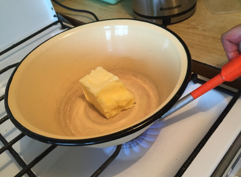 1. Этап. Манник с сухофруктами: Тем временем возьмите металлическую эмалированную посуду и положите туда масло. Растопите его на слабом огне. Следите за тем, чтобы масло не закипело.