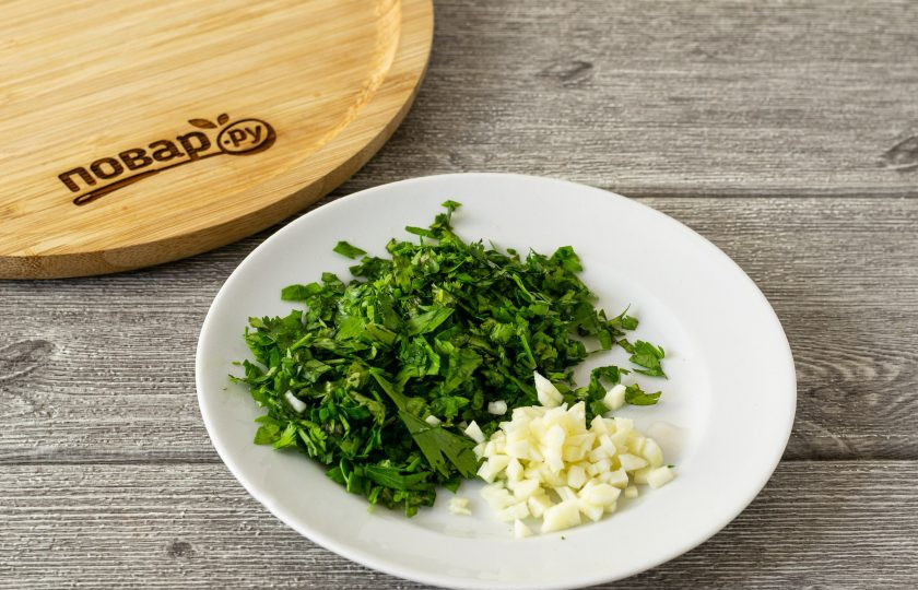 1. Этап. Маринованные перцы по-корейски на зиму: Чеснок очистите и мелко порубите, зелень тоже измельчите.