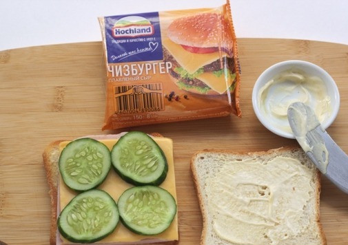 1. Этап. Просто сэндвич: Затем слой тонко нарезанного огурчика. Второй кусочек хлеба также смазать соусом с обжаренной стороны и выложить сверху. Прижать сэндвич, можно выложить на него толстую разделочную доску или другой пресс. Здесь важно прессануть сэндвич, чтобы он не развалился на составляющие ингредиенты и держал форму.