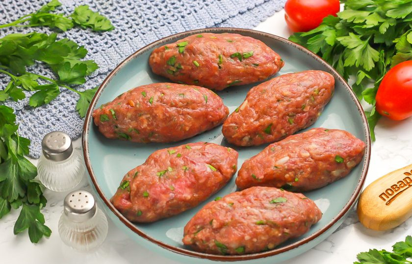 1. Этап. Котлеты по-турецки: Смочите руки в воде и разделите фарш на равные части. Сформируйте в руках заготовки котлет, округляя их. Котлеты по-турецки должны быть продолговатой формы.