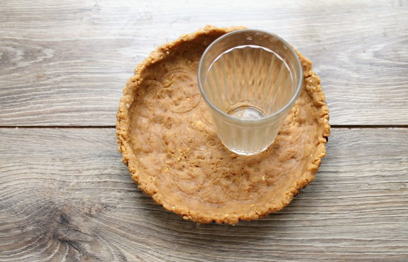 1. Этап. Корж из печенья без выпечки: Разъемную форму застелите пленкой или бумагой для выпечки. Переложите в форму массу из печенья и, утрамбовывая, сделайте небольшие бортики и дно. Уберите в холодильник на 30-60 минут.